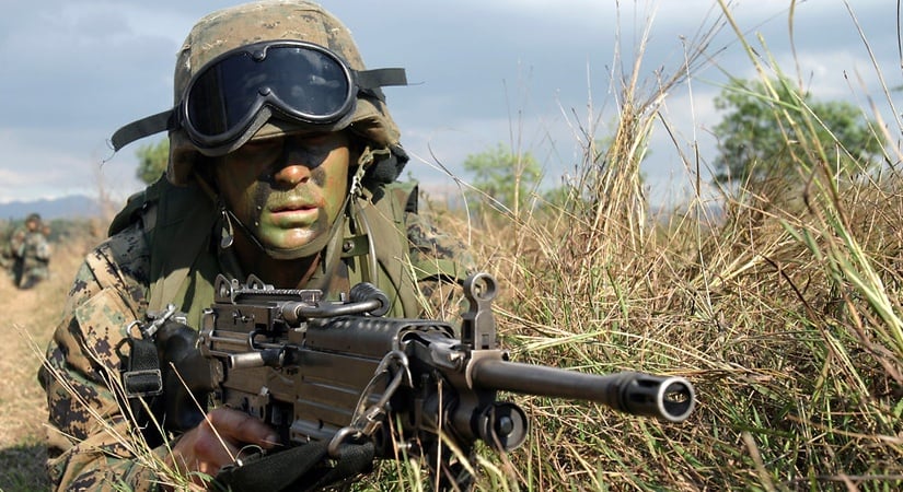 Camouflaged soldier in grass