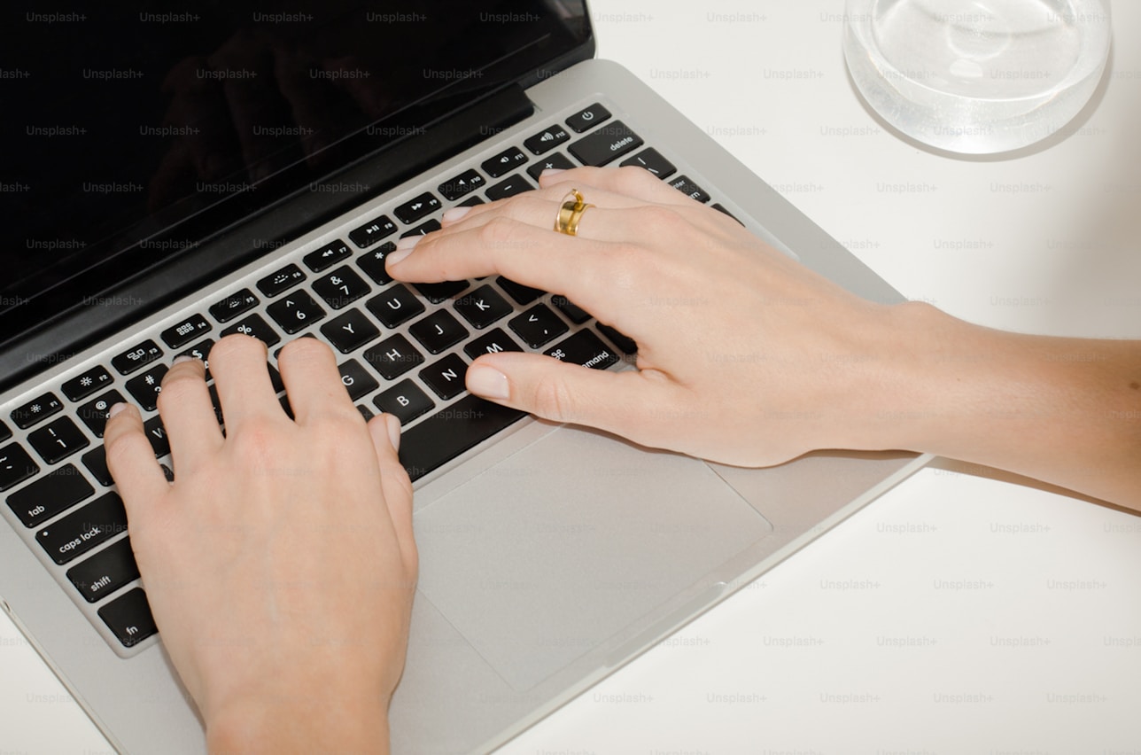 Hands typing on laptop