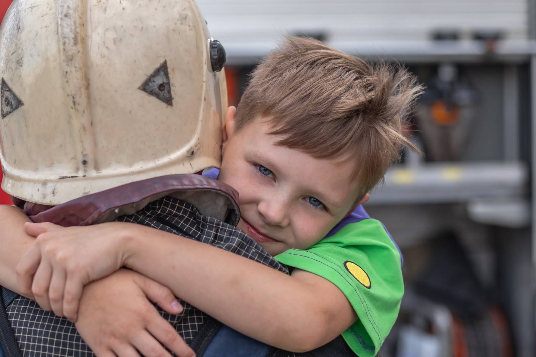 Boy hugging fireman