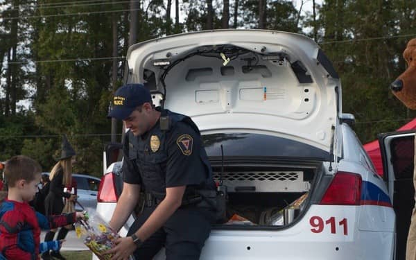 Police officer passing out candy to trick-or-treaters